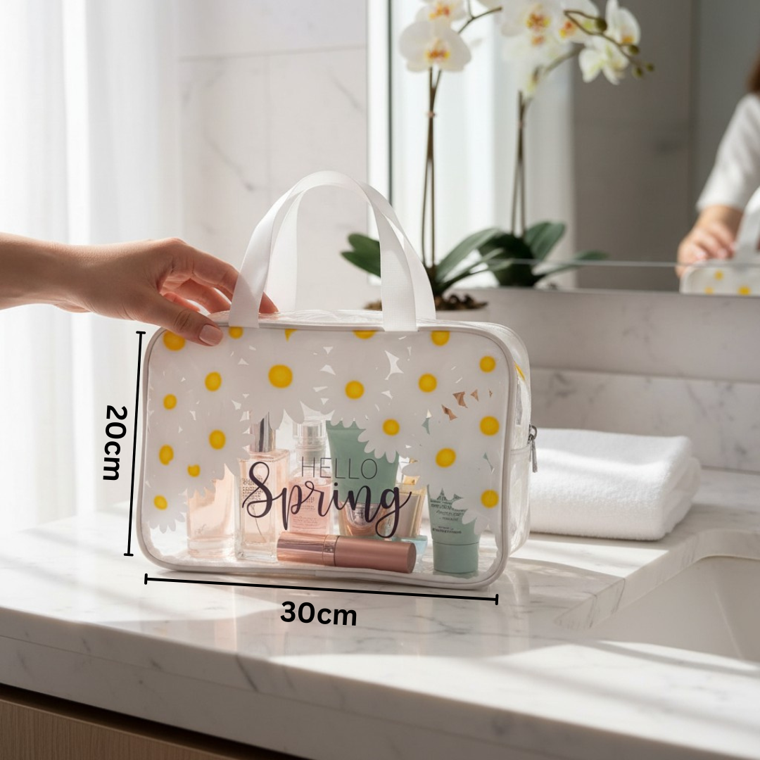 Clear travel bag with yellow polka dots containing cosmetic items on a marble surface.