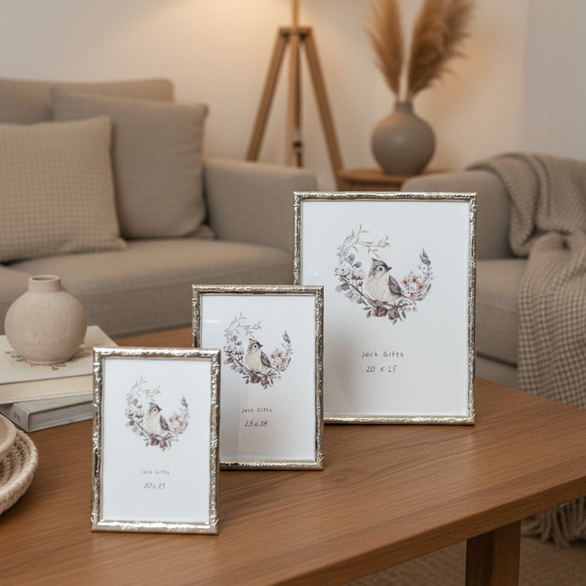 Three framed pictures on a wooden table in a living room setting.