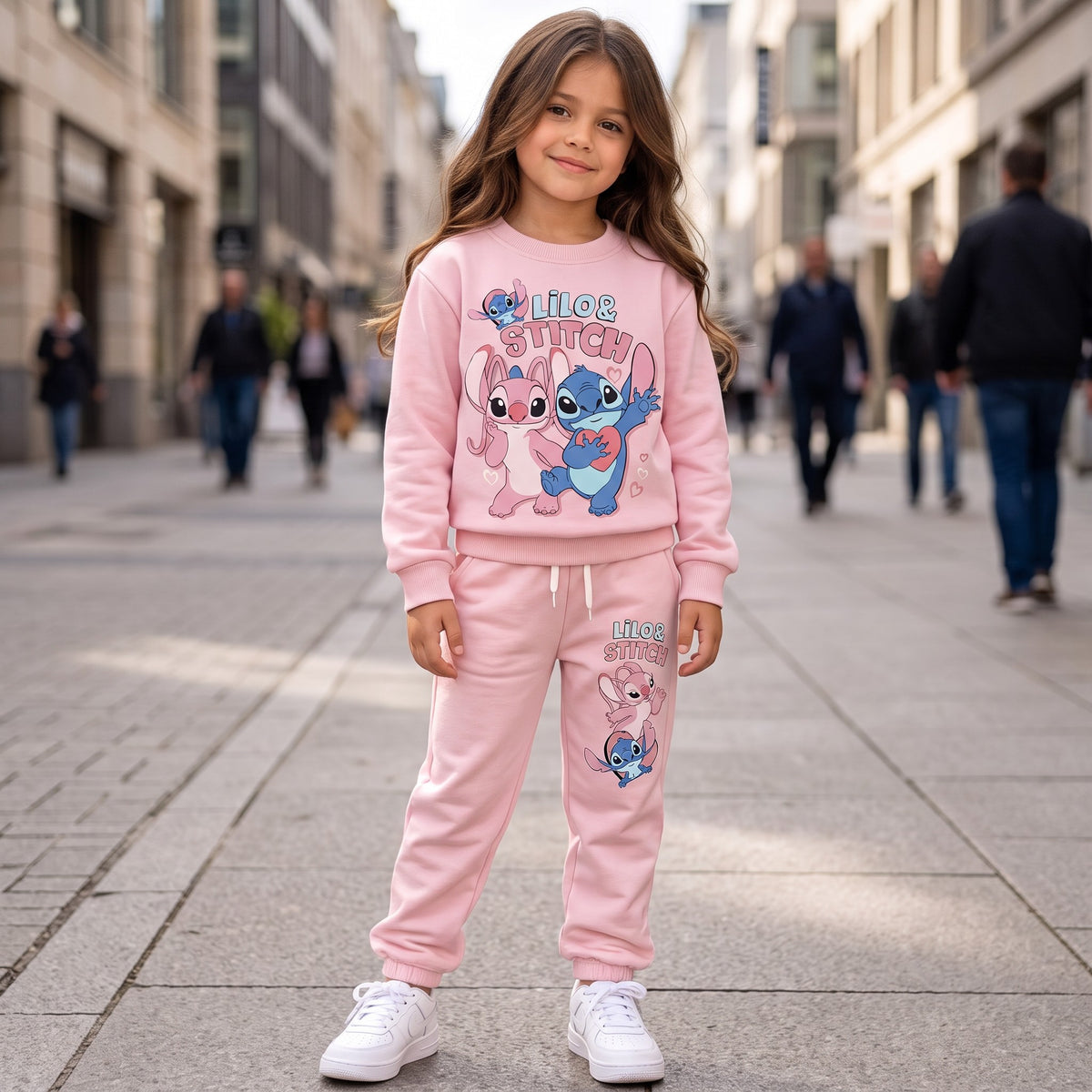 Girl in a baby pink stitch sweatshirt and matching pink joggers on a street