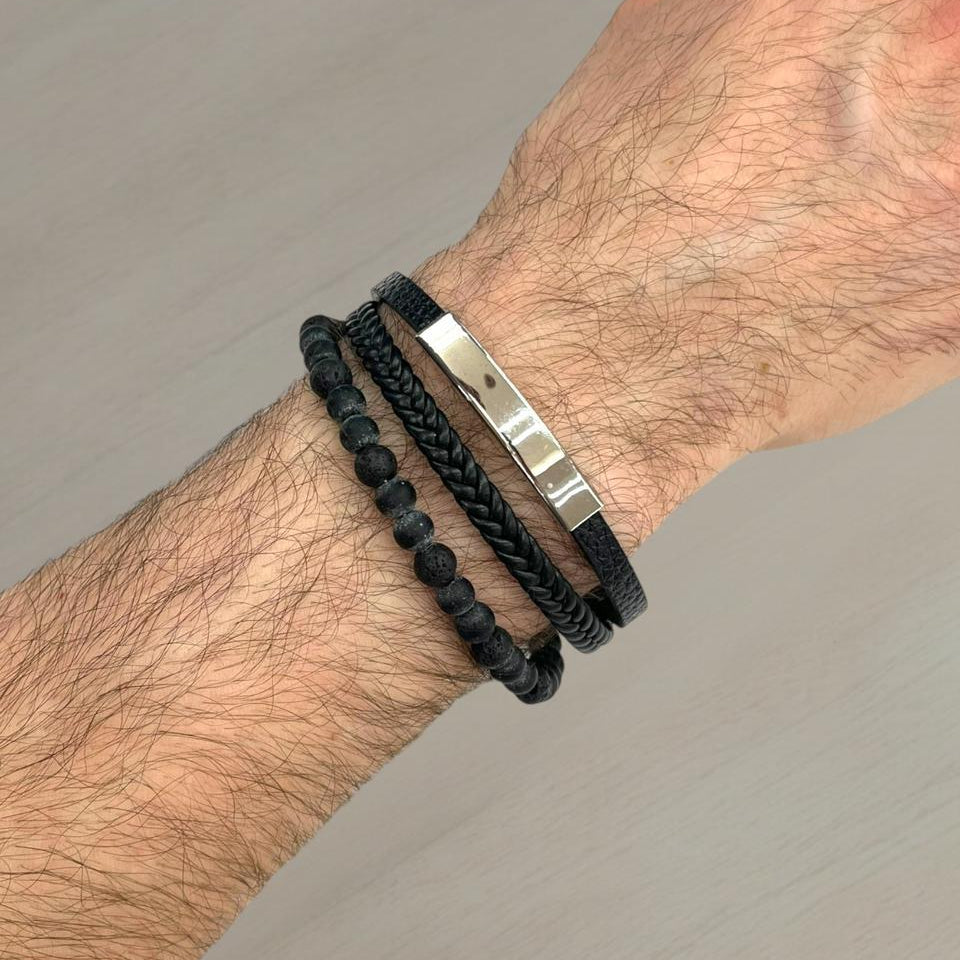 Black lava stone bead and braided leather bracelet with a silver bar on a wrist