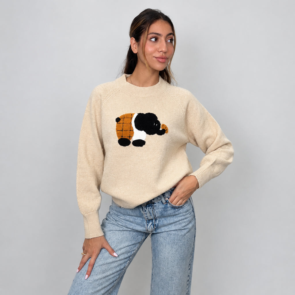 Beige elephant patch sweater with raglan sleeves, one hand on hip