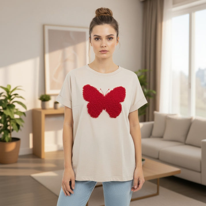 Woman wearing a white tshirt with a red butterfly design in a living room