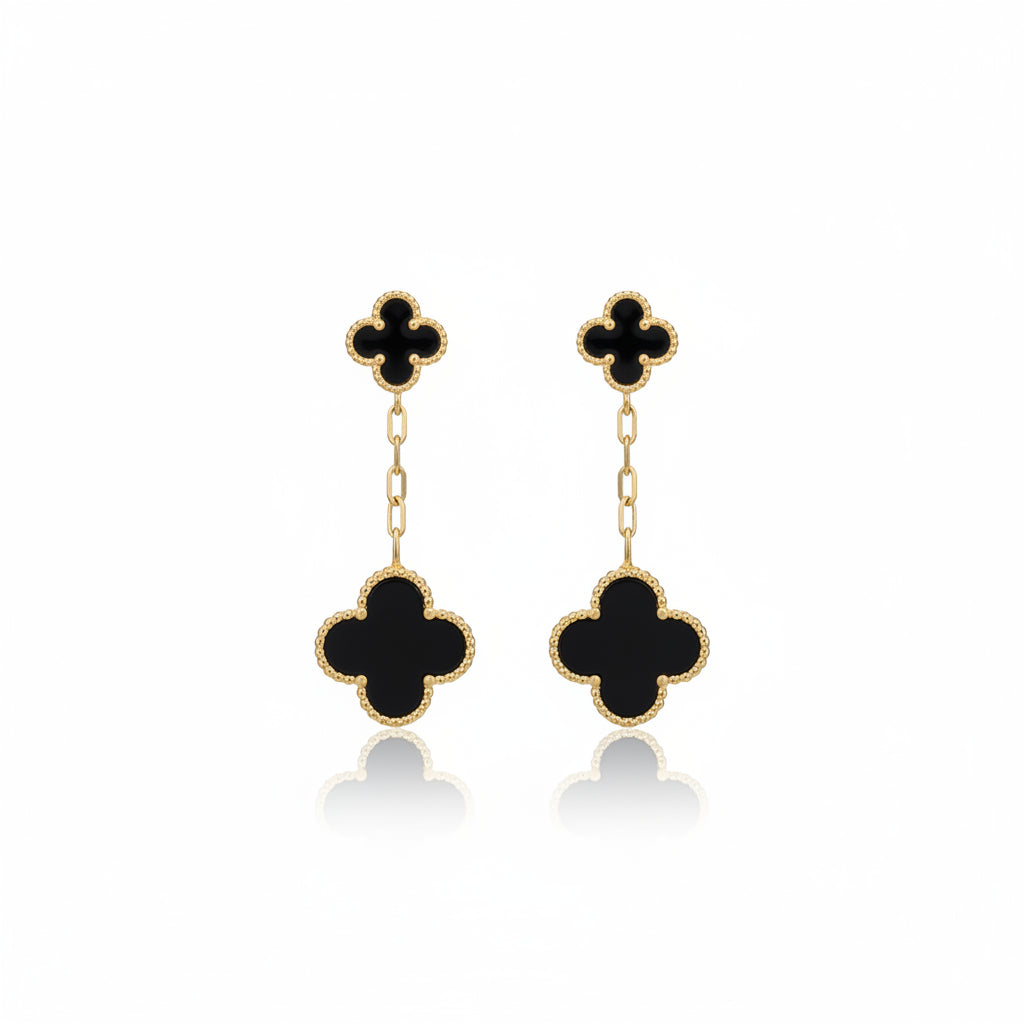 Black clover-shaped earrings on a white background