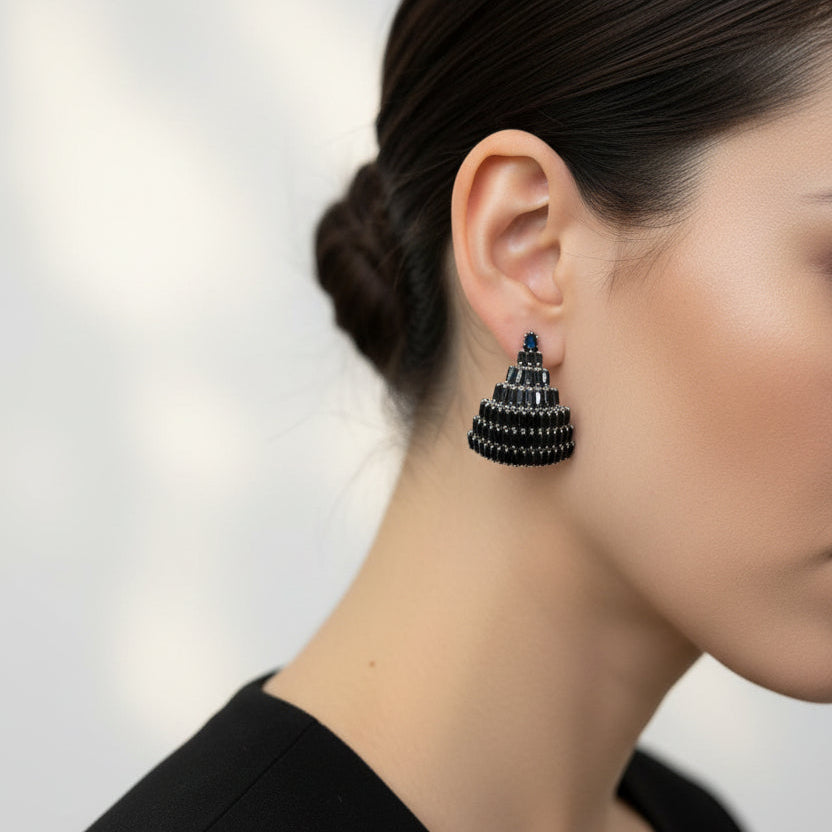 Close-up of a person wearing a black earring with a blurred background