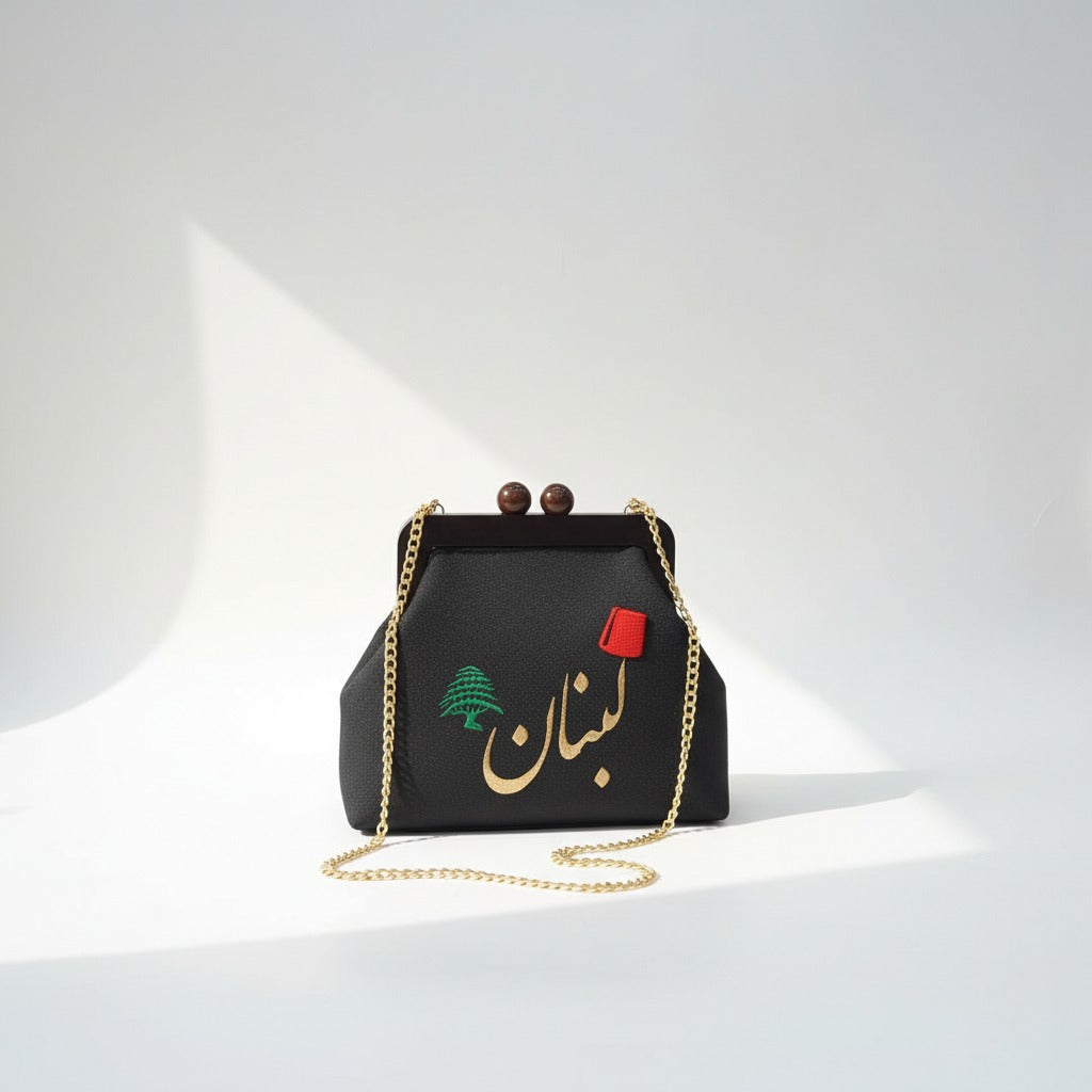 Black pebbled frame bag with wooden ball clasps, a green cedar and gold Arabic lettering