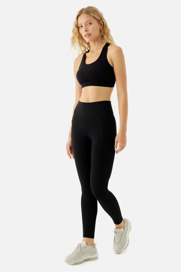 Woman wearing a black athletic outfit on a white background