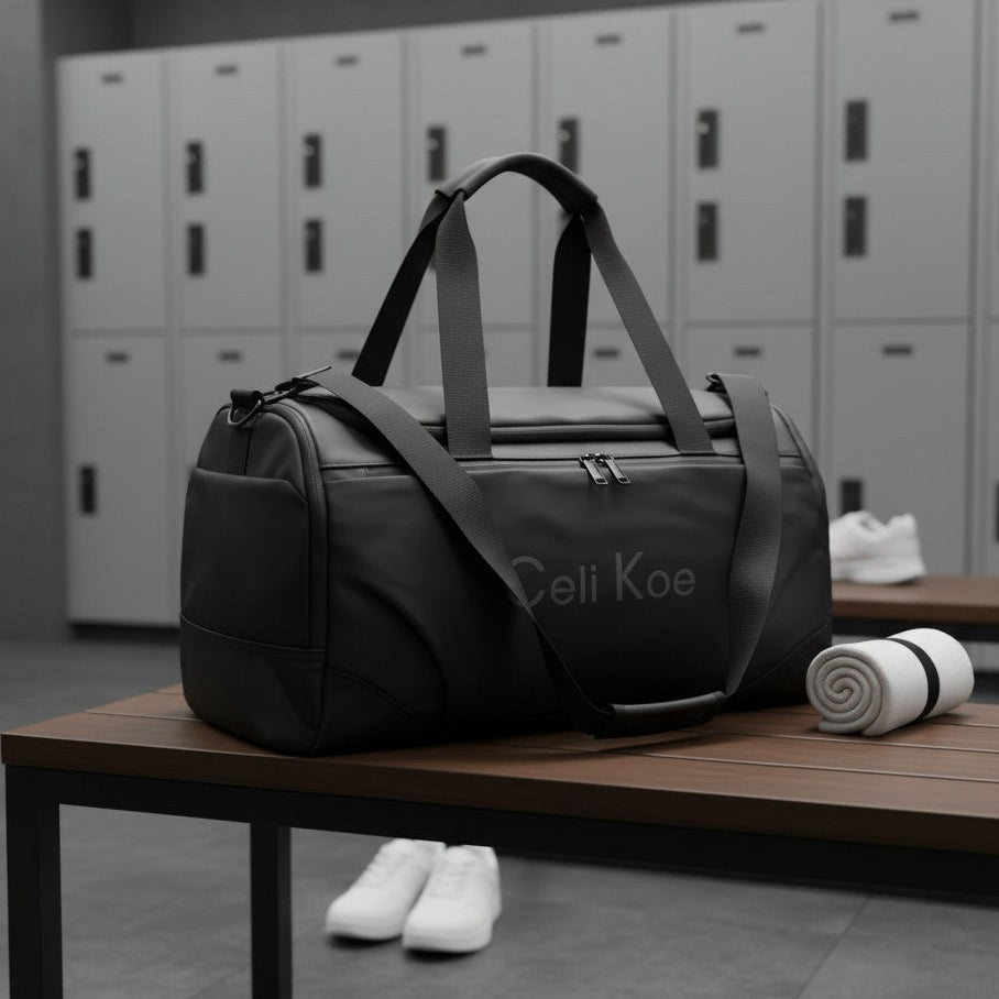 A black duffle bag with grey handles and a grey printed logo sits on a wooden bench in a gym setting