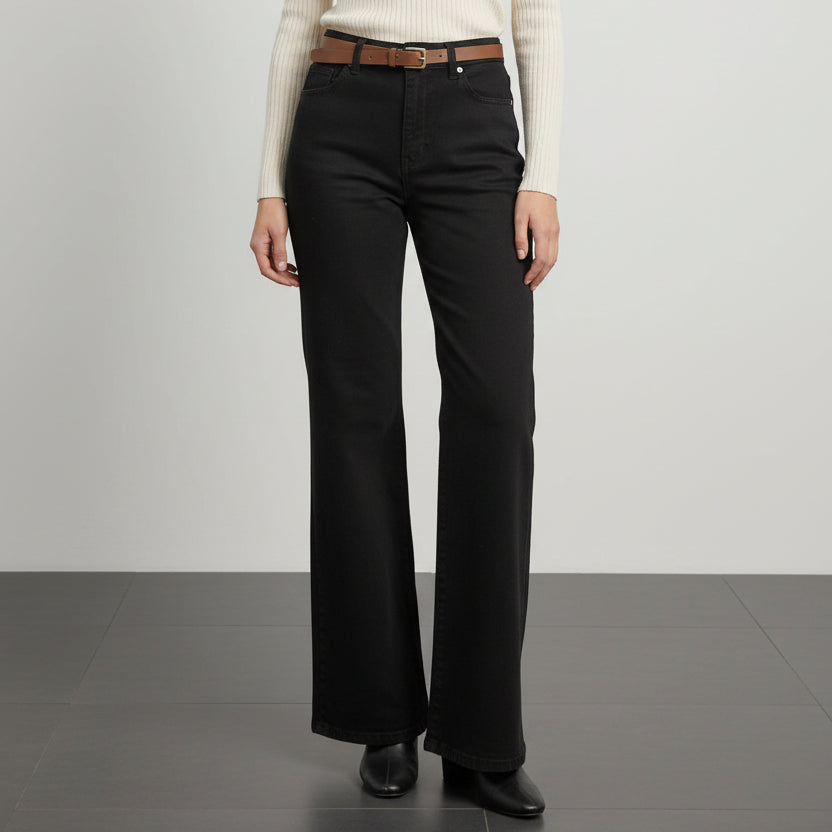 Person wearing black wide-leg pants with a brown belt on a white background