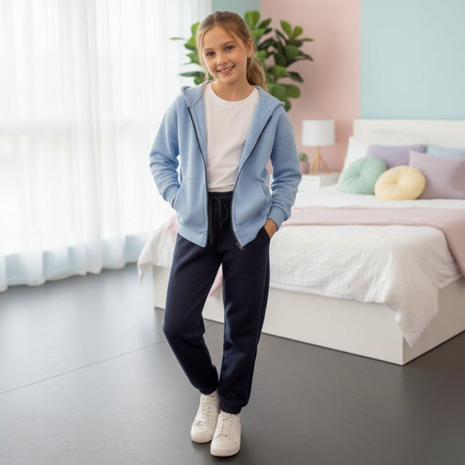 Girl in a light blue zip up hoodie and navy cuffed joggers