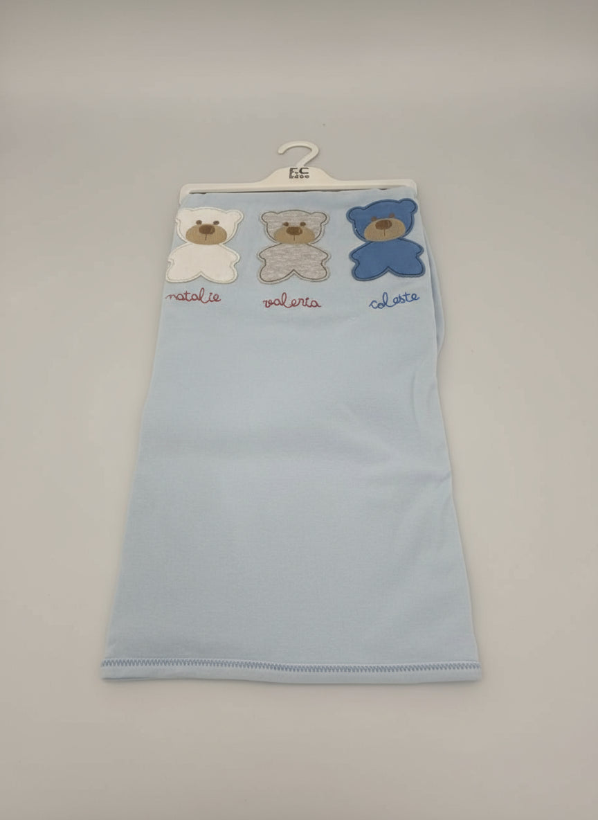 Pale blue baby blanket hung on a hanger, white, grey and blue bears, contrast overlock stitched hem