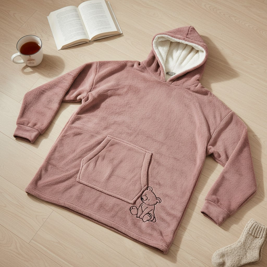 Blush pink hooded blanket laid flat showing the sherpa hood, front pocket and bear motif