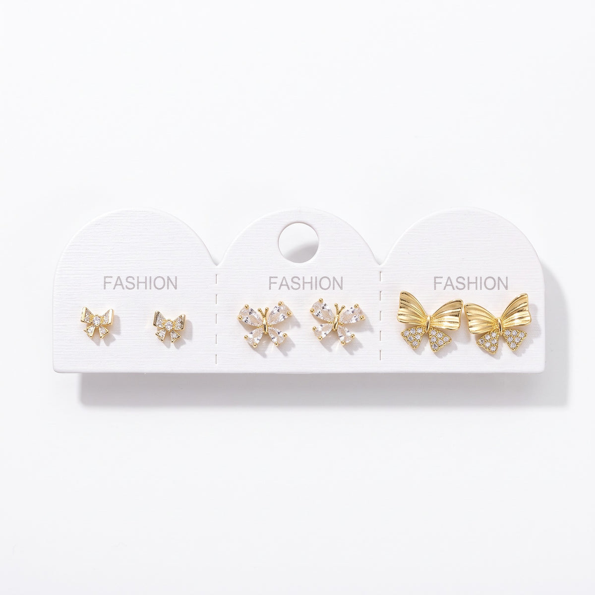 Crystal bow, crystal butterfly and large gold bow stud earrings on one card