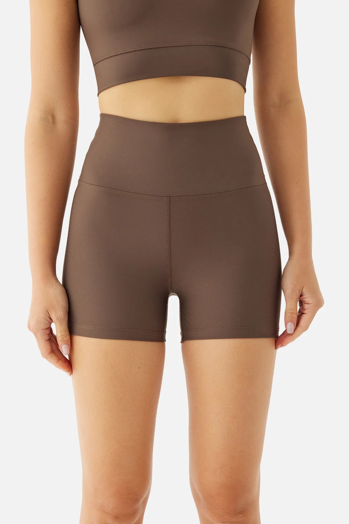 Brown athletic top and shorts worn by a person on a white background