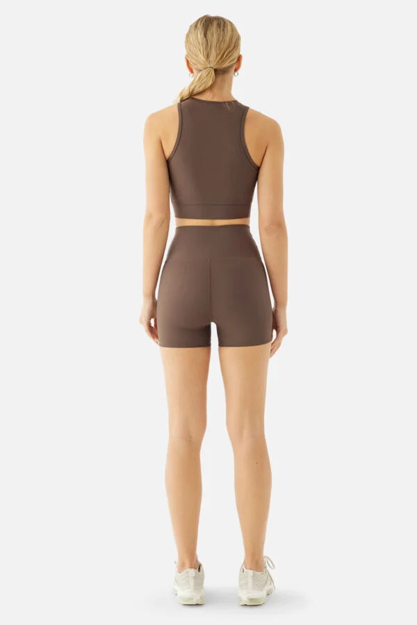 Person wearing a brown athletic outfit on a white background