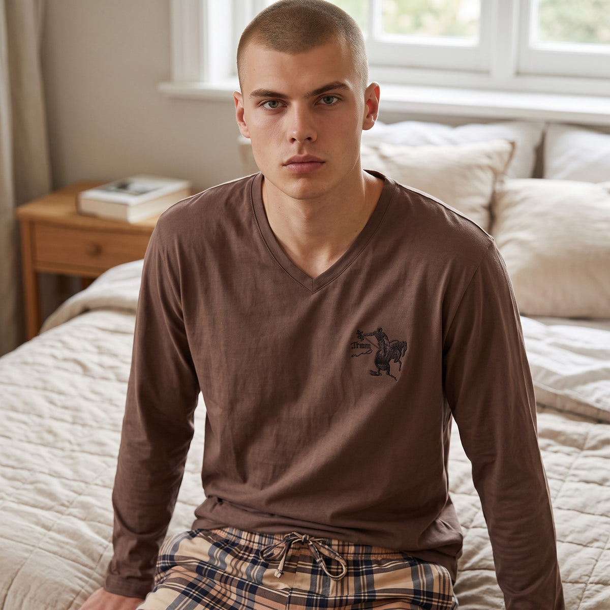 Close view of the brown pyjama top showing the V neckline and small chest motif