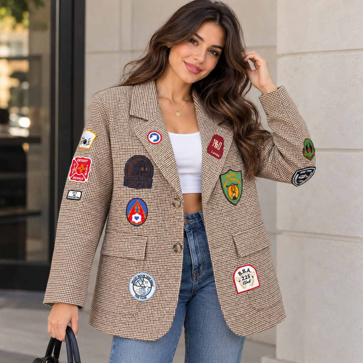 Woman in a brown houndstooth blazer covered in colourful embroidered patches with jeans