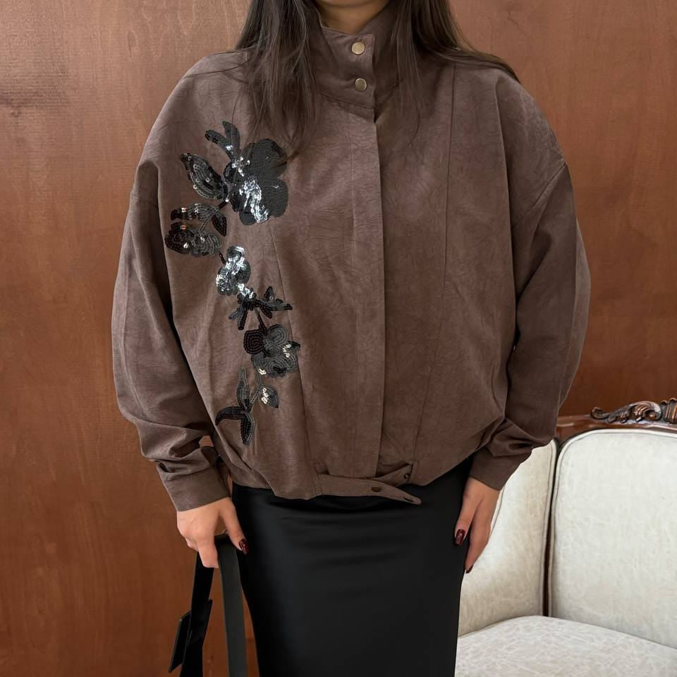 Brown oversized jacket with black sequin flowers down one side, a high collar and snap tab hem