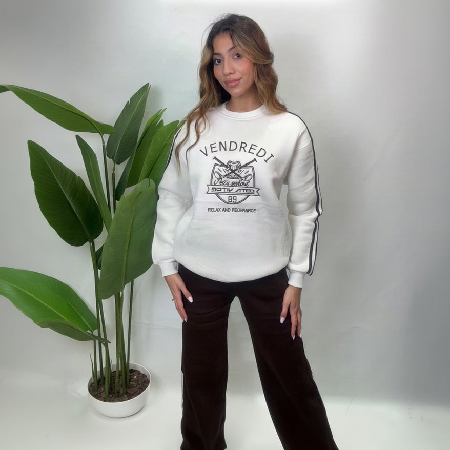 White varsity print sweatshirt with dark sleeve stripes and brown wide leg pants