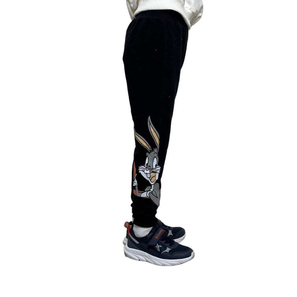 Side view close up of the grey cartoon rabbit printed on the lower leg of black joggers