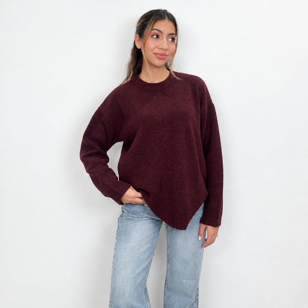 Burgundy chunky wool knit sweater with a crew neck, hand in pocket with light wash jeans