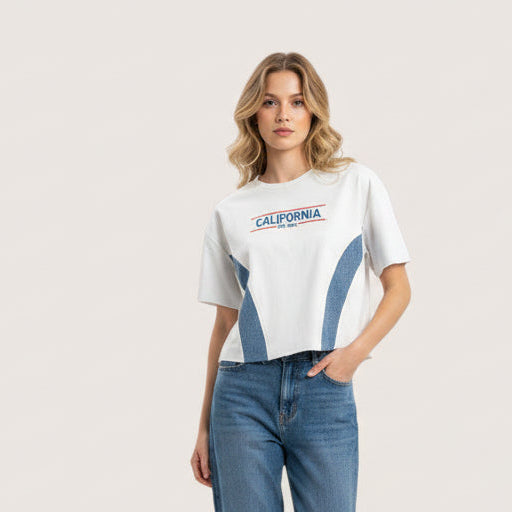 Woman wearing a white tshirt with 'California' text and blue jeans on a light background
