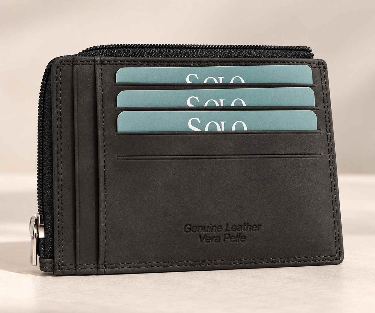 Dark charcoal leather card holder with three teal cards and a silver zip along the top