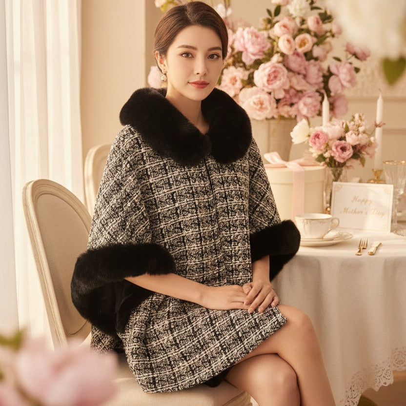 Woman in a stylish puncho sitting at a table with floral decorations
