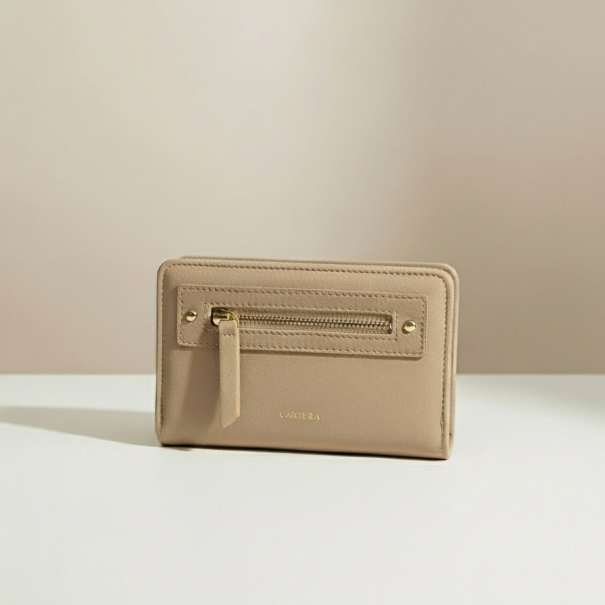 Beige wallet with gold zipper on a light beige background