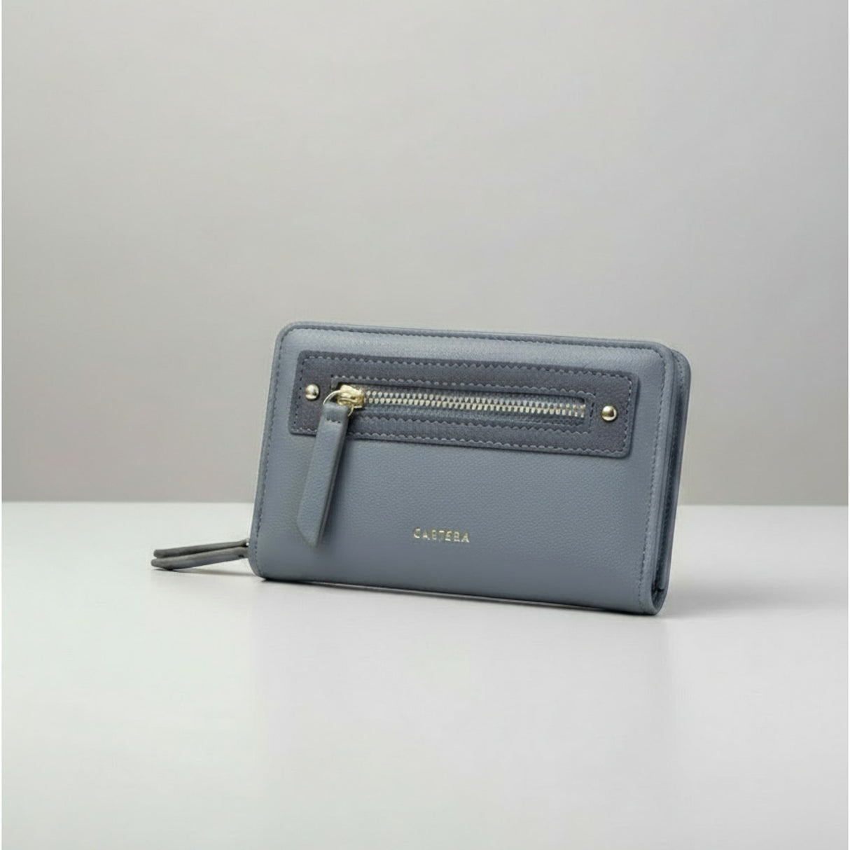 Blue women's wallet with zip pocket and gold details on a grey background