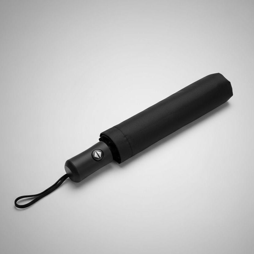 Black folding umbrella closed with its strap fastened