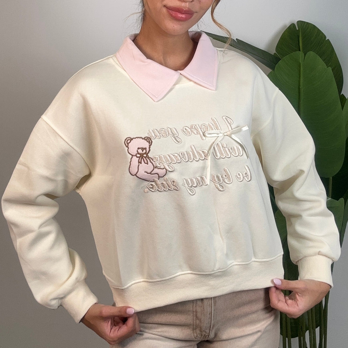Cream collared sweatshirt with a pink collar, embroidered teddy bear and script slogan