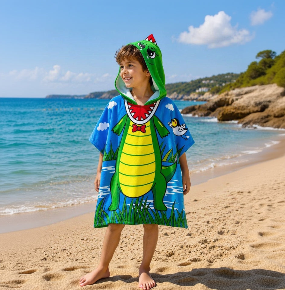 Kid wearing a crodcodile poncho standing on the beach