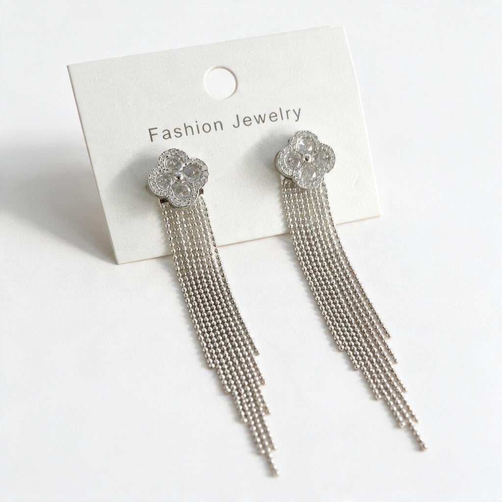 Silver tone crystal clover studs with bead chain fringe on a cream card