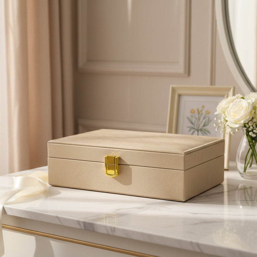 Champagne velvet jewelry box closed on a marble console beside white roses