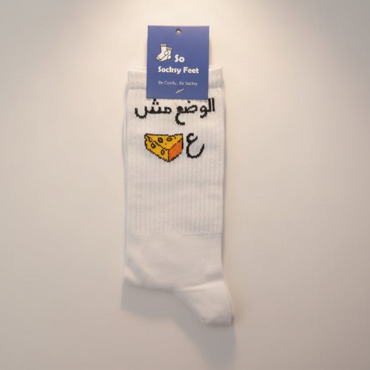 White crew socks knitted with an Arabic phrase and a yellow cheese wedge motif
