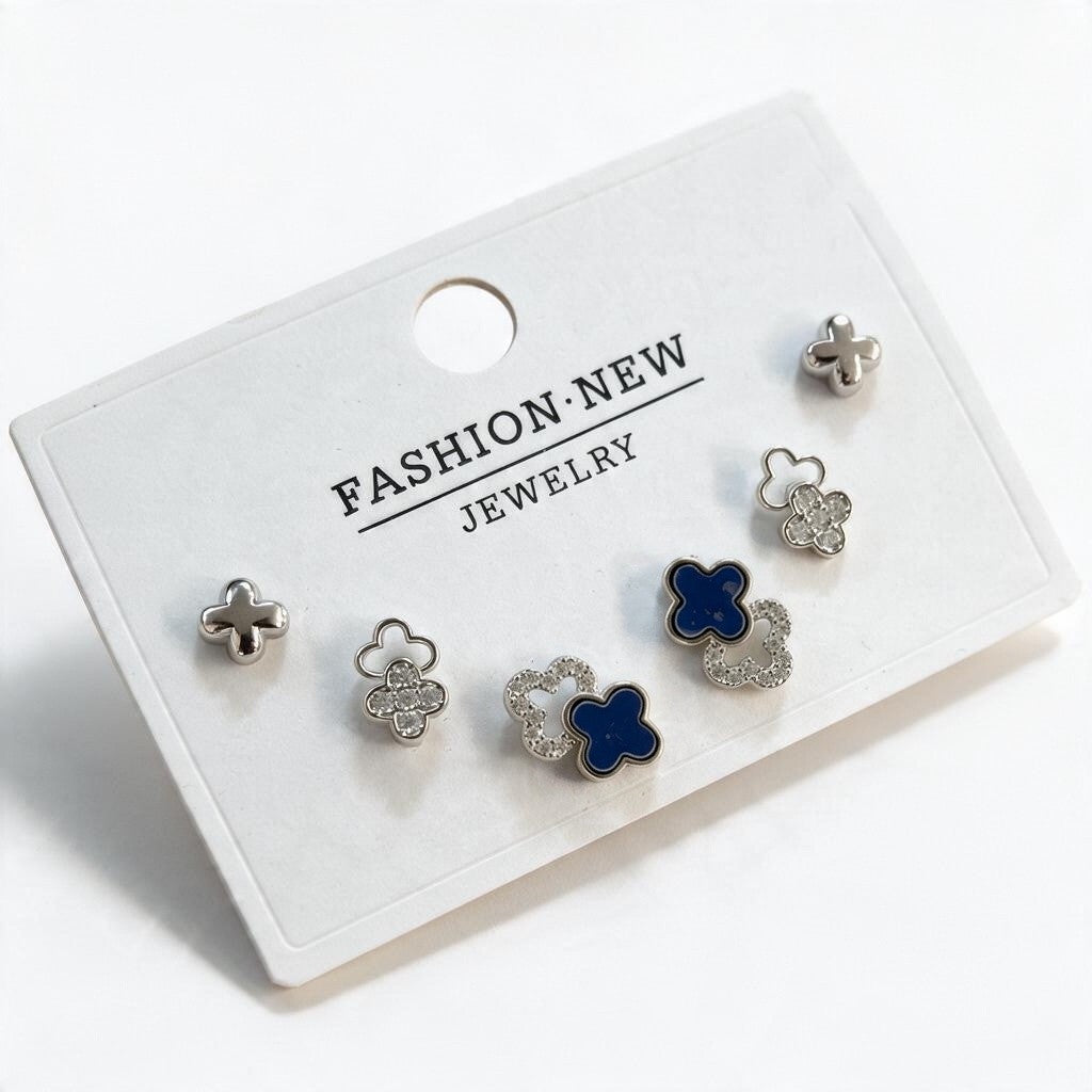 Silver tone clover stud set with polished crosses, pave outlines and navy enamel clovers on a card
