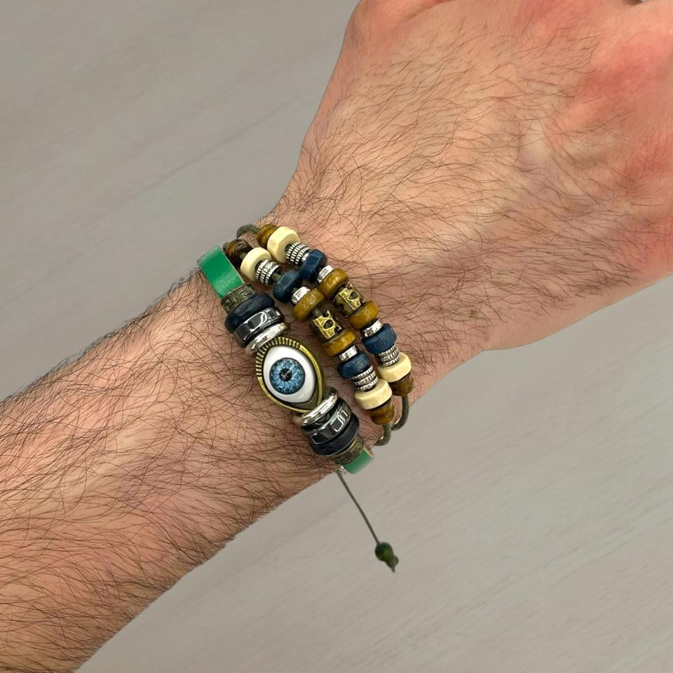 Eye charm bracelet stack with green, cream and brown beads on a wrist