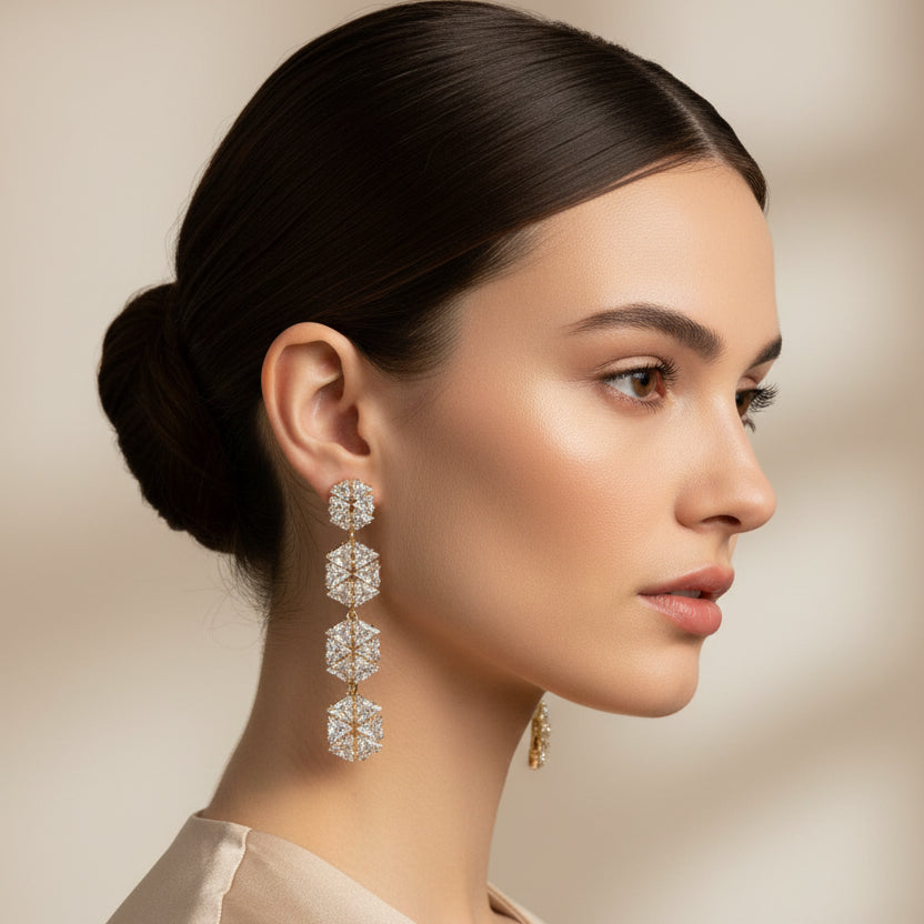 Pair of diamond-studded floral earrings worn by a woman on a beige background