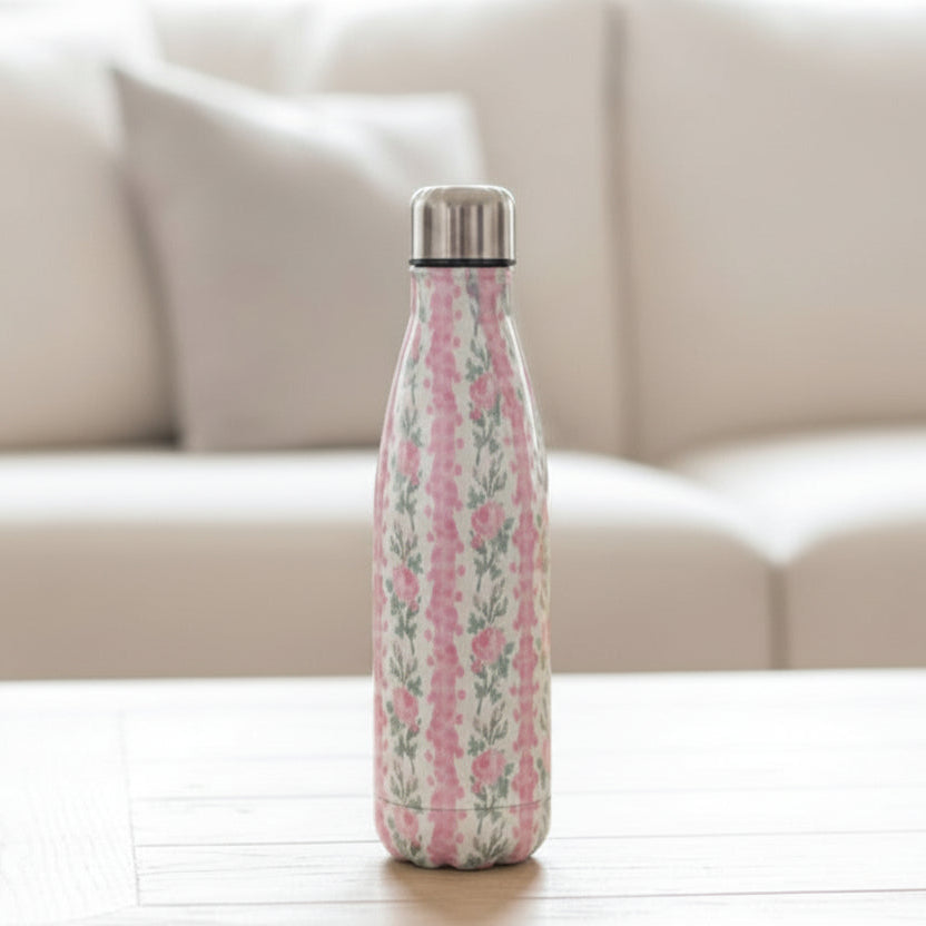 Cream vacuum flask with vertical pink rose stripes on a white wood table