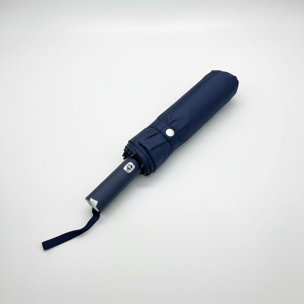 Folded navy blue umbrella on a light grey background