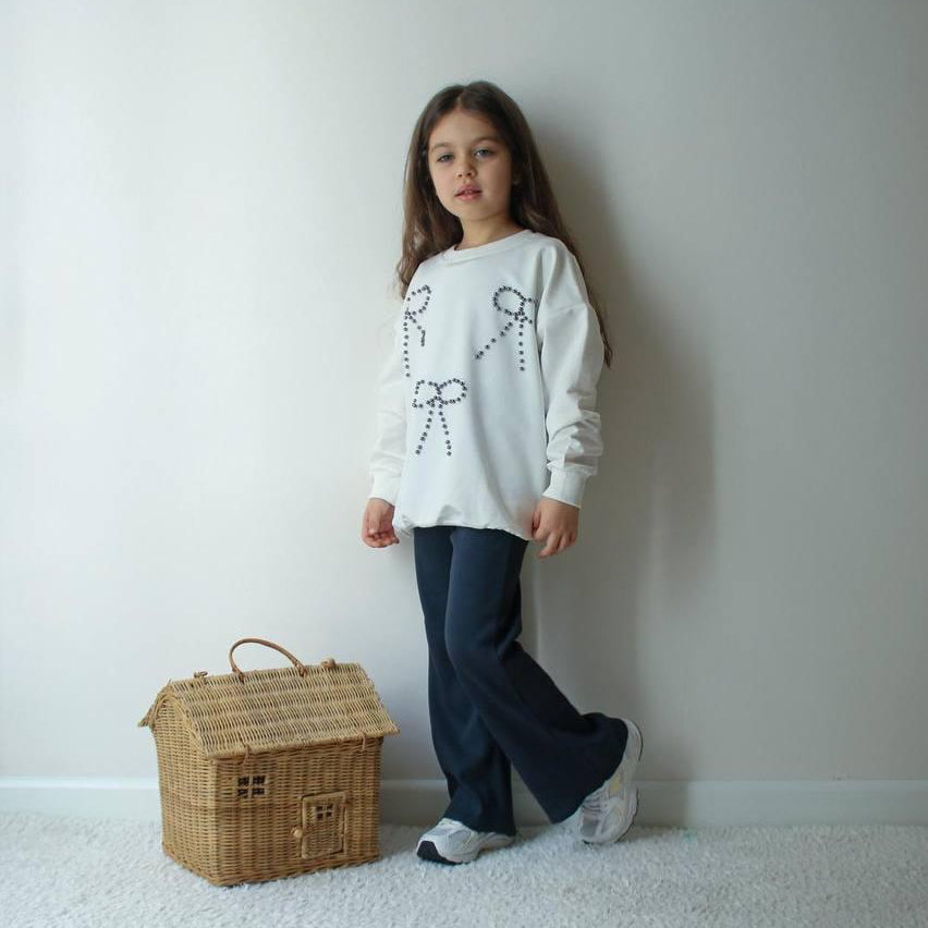 Cream sweatshirt with three beaded bows and navy flared pants