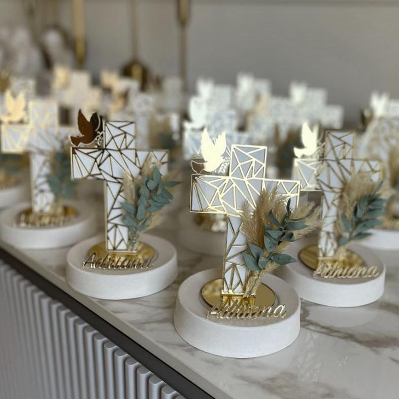 White lattice cross with a gold dove on a round base, a name in gold script below
