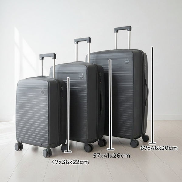 Dark grey suitcase set with telescopic handles raised in a bright room