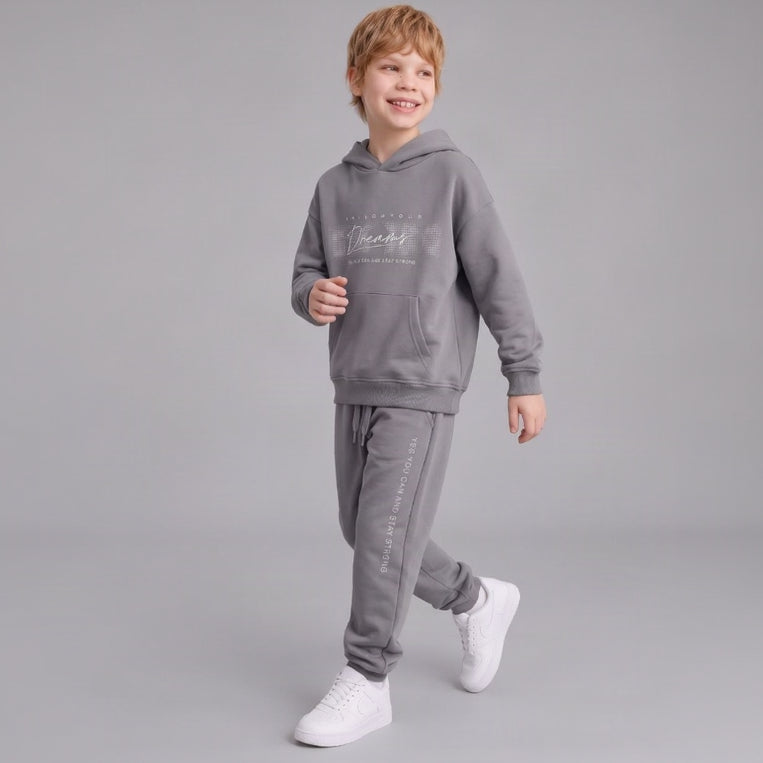 Smiling boy in a grey Follow Your Dreams hoodie and matching joggers