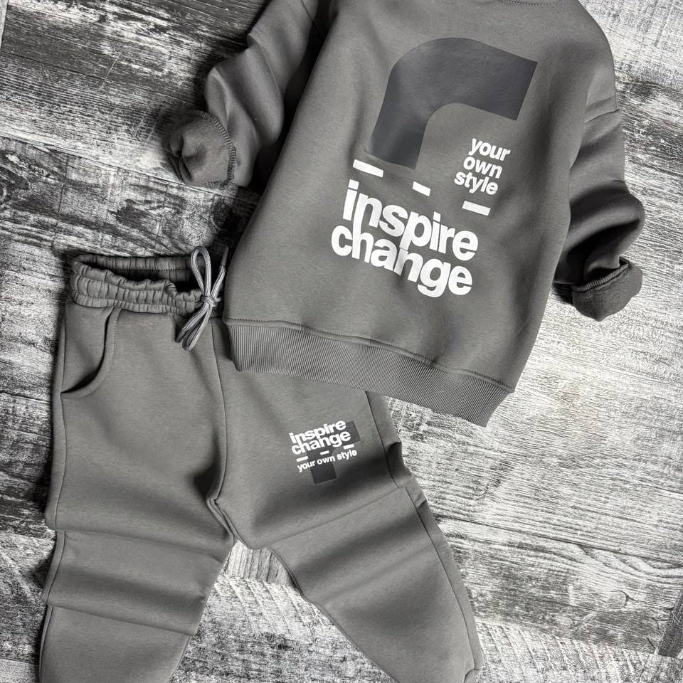 Grey sweatshirt laid flat showing the back print above matching joggers