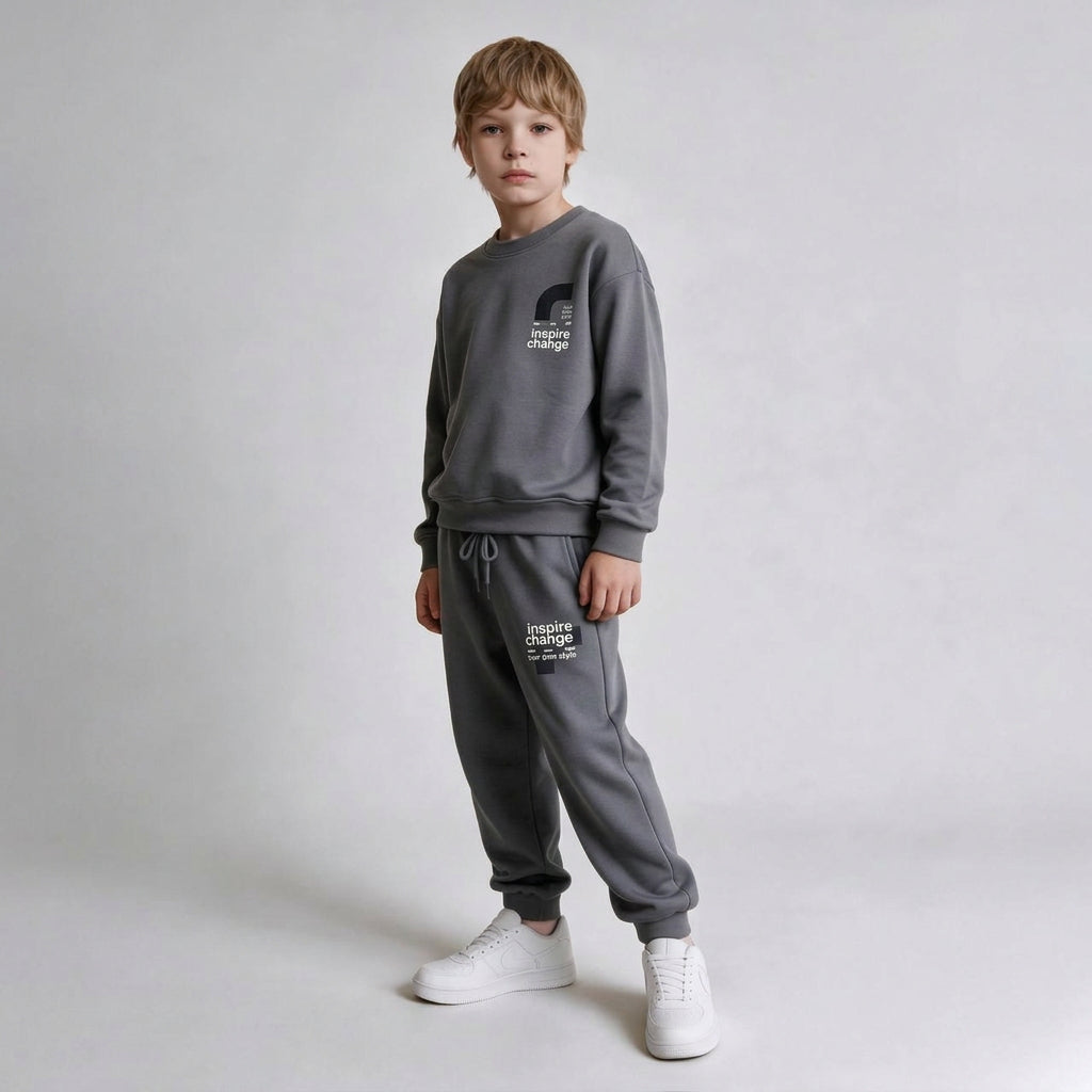 Boy in a grey crew neck sweatshirt and drawstring joggers with white sneakers
