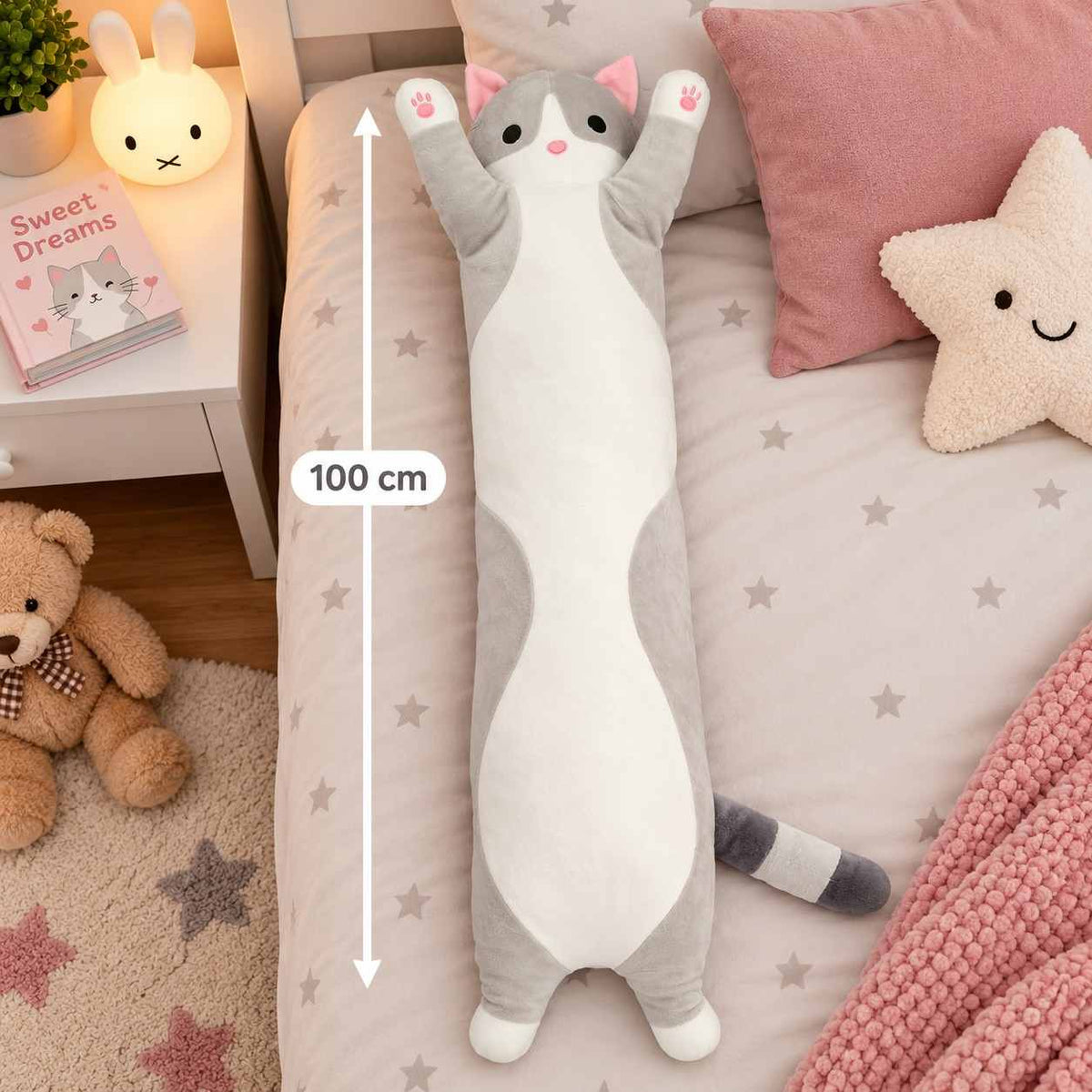Grey long cat body pillow plush on a star print bed with a 100 cm measuring line and a star cushion