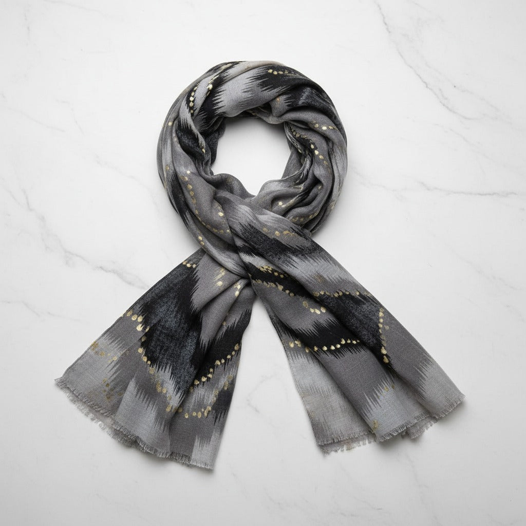Grey scarf with black and gold pattern on a white background