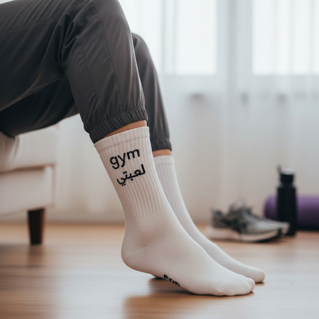Person wearing white socks with 'gym' text in a home setting
