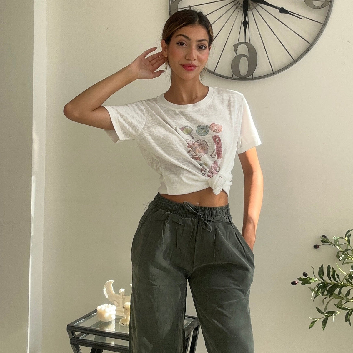Heart print crop tee styled with khaki green trousers and a raised hand